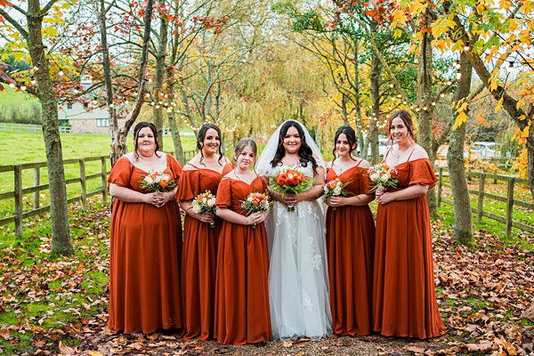 Bride and bridesmaids in autumnal outdoor setting