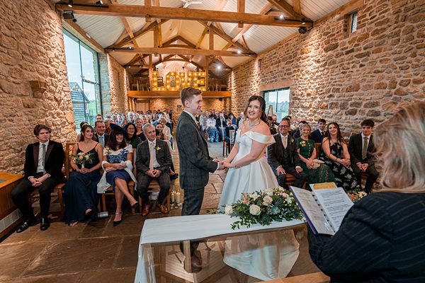 Couple exchanging vows at rustic wedding ceremony.