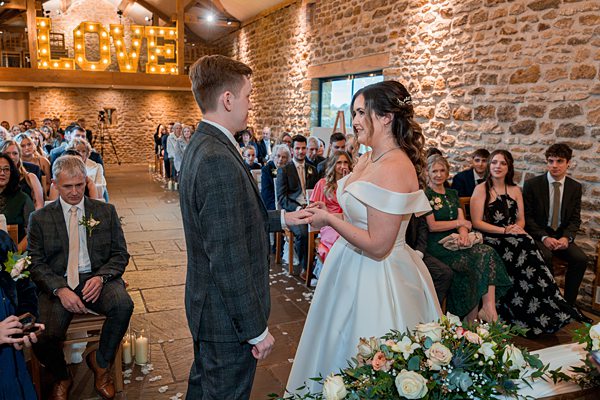 Bride and groom exchanging vows at wedding ceremony.