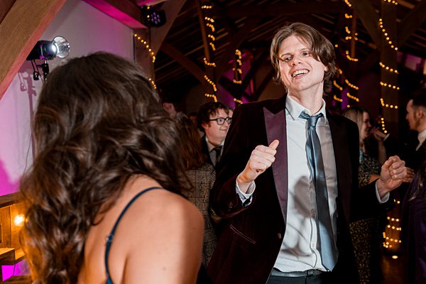 Man dancing at festive indoor party.