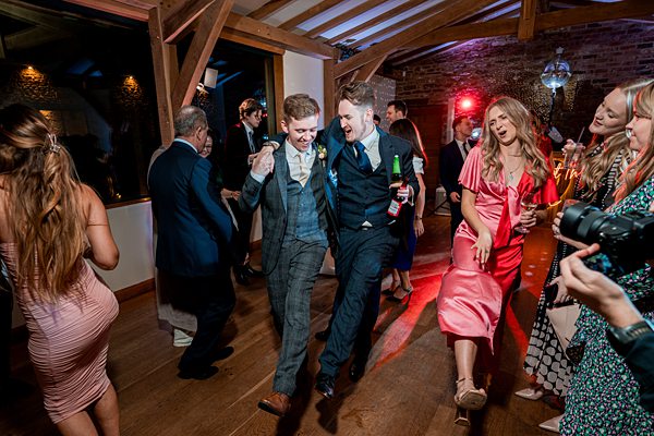 Guests dancing at evening wedding reception.