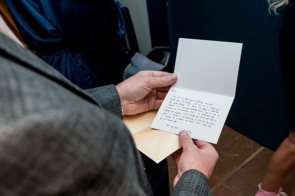 Person reading handwritten note from envelope.
