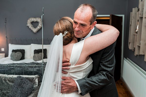 Bride embracing father at wedding.