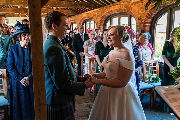 Bride and groom holding hands at wedding ceremony.