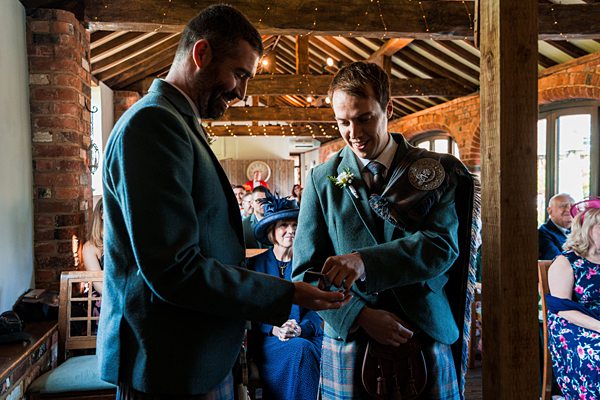 Two men exchanging rings at wedding ceremony.