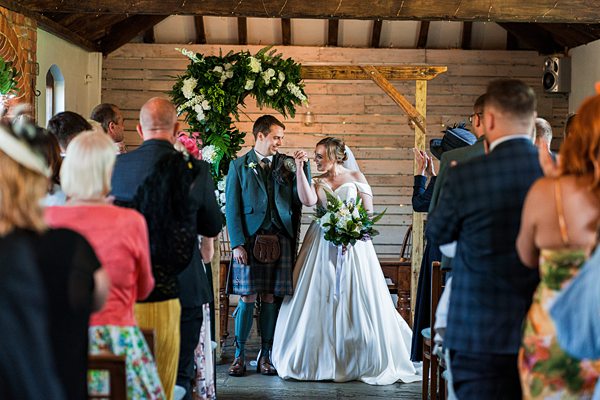 Bride and groom at rustic wedding ceremony.