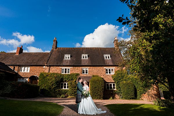 Couple embracing at British countryside wedding.