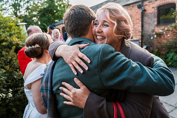 Woman joyfully hugging man at outdoor gathering.