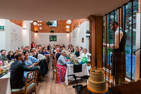 Guests enjoying speech at intimate wedding reception.