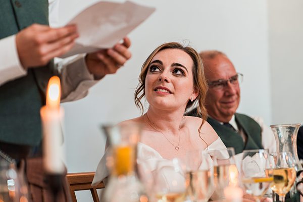 Woman listening to speech at wedding reception.
