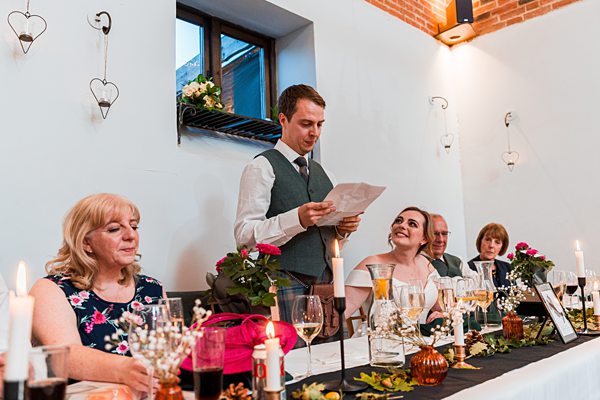 Man giving speech at wedding reception table