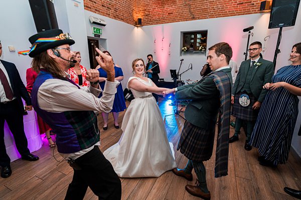 Wedding dance with guests in a Scottish-themed celebration.