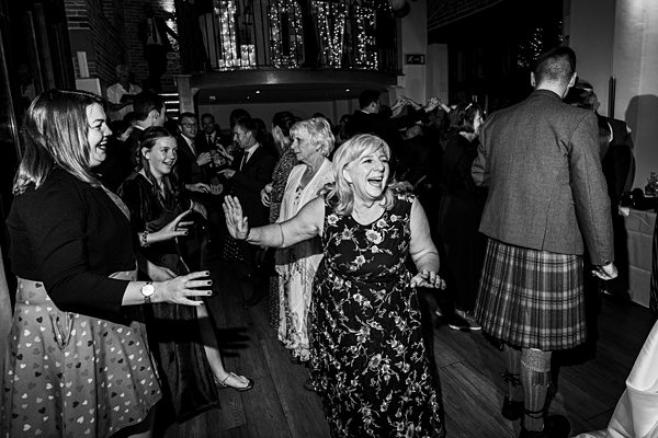 Guests dancing at black and white wedding reception.