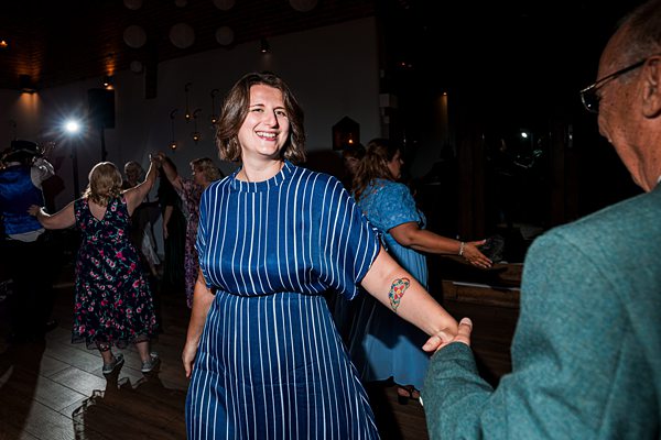 Woman dancing at festive event with others.