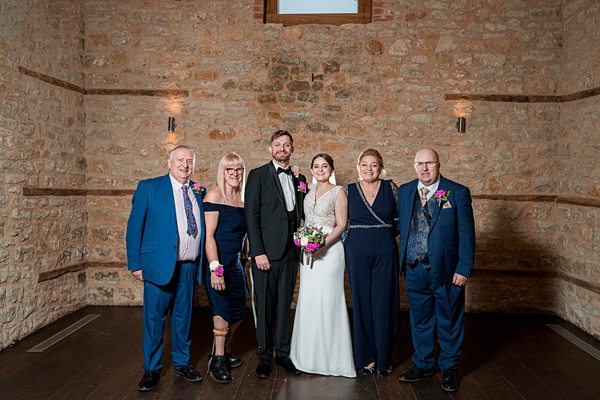 Family at wedding in rustic stone hall.
