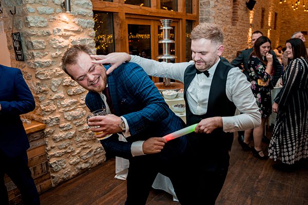 Men joking around at a lively party event.
