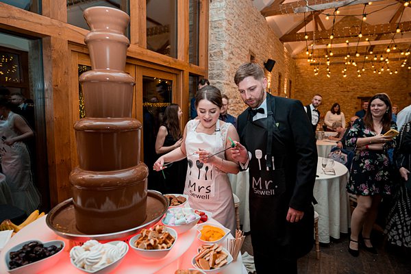 Couple enjoying a chocolate fountain at a wedding reception.