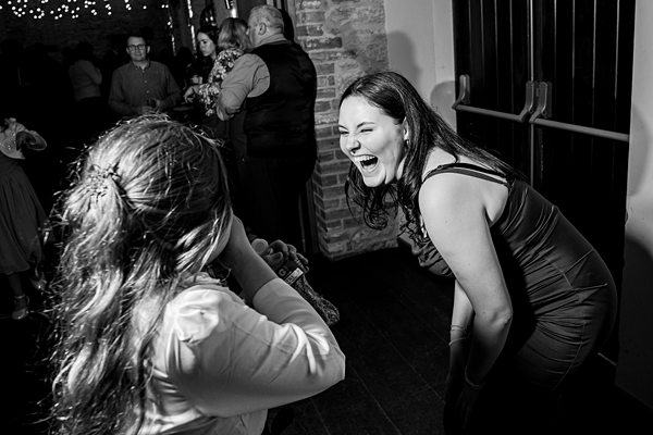 Women laughing joyfully at celebration event.