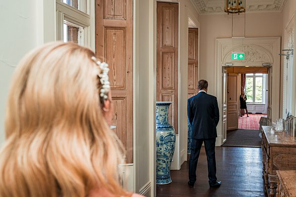 Elegant hallway, woman watching man walk away.