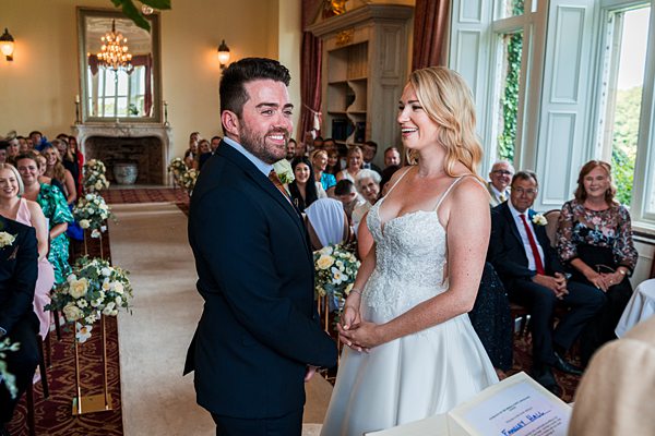 Bride and groom holding hands at wedding ceremony.