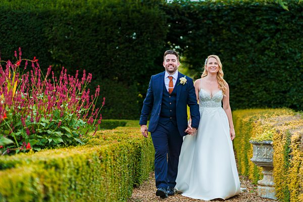 Couple walking in garden at wedding.