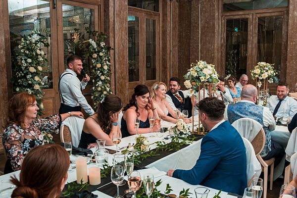 Wedding guests enjoying dinner at rustic venue.