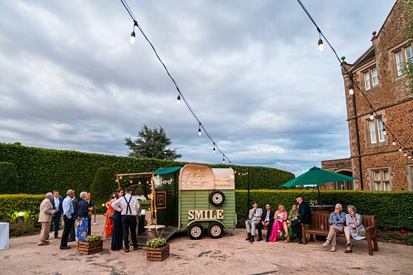 Outdoor event with food truck and string lights.