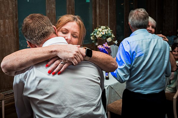 Two people hugging at a social event.