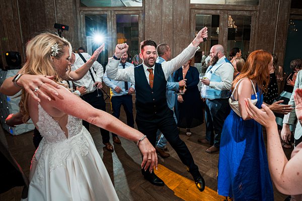 Wedding guests dancing at reception party.