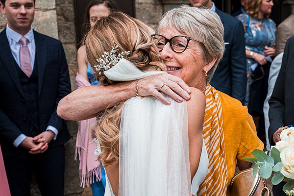 Bride embracing older woman at wedding celebration.