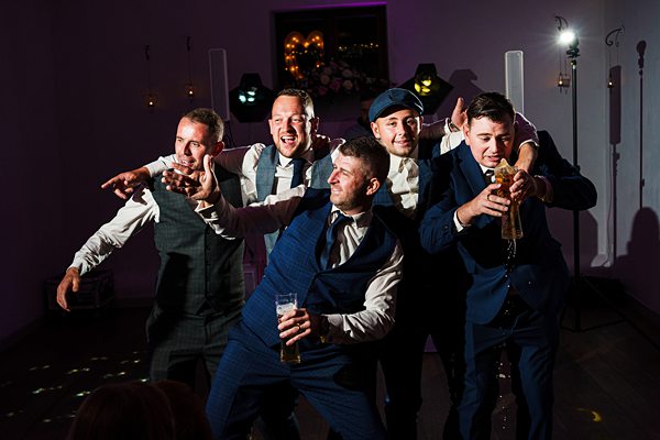 Group of men posing playfully at event.