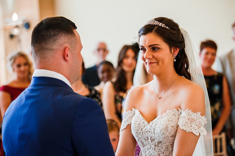 Bride and groom facing each other at wedding ceremony.