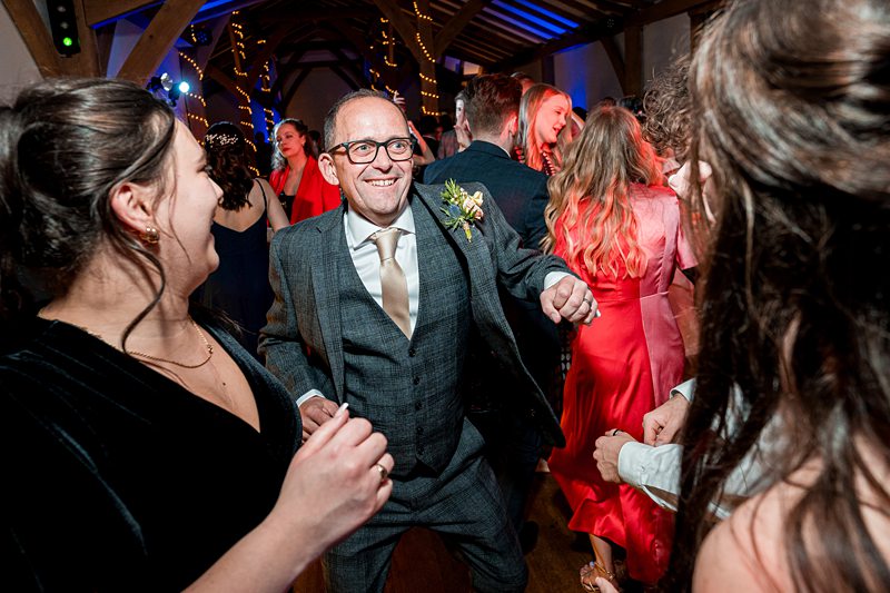 Joyful wedding reception dance floor scene.