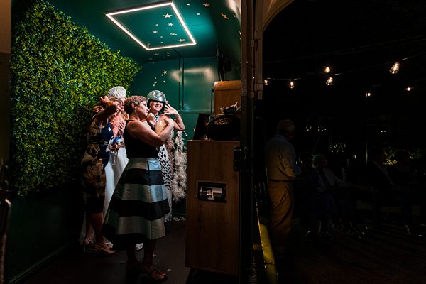 Women in photo booth at evening event.