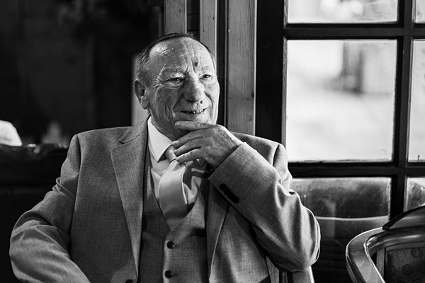 Elderly man pondering in black and white photograph.