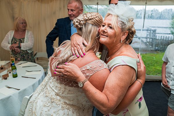 Emotional embrace at wedding reception.