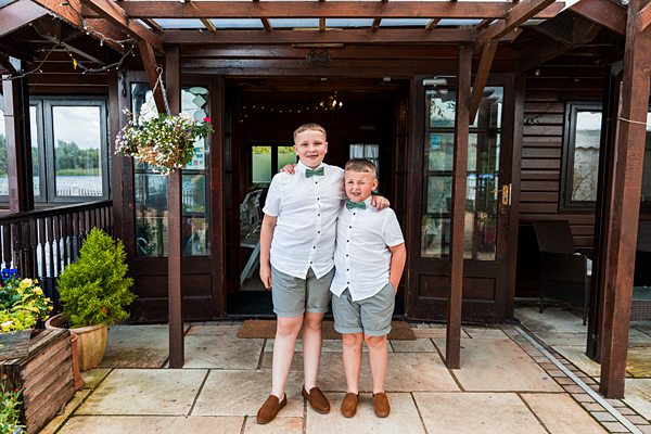 Two boys smiling in semi-formal attire outside.