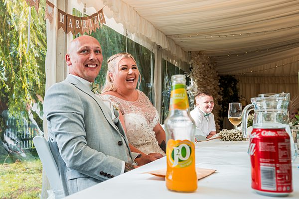 Happy couple at wedding reception, laughing.