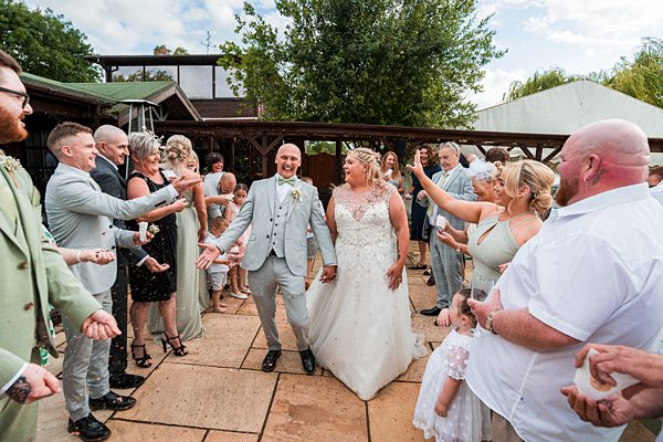 Joyful couple at outdoor wedding celebration.