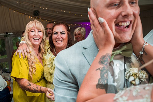 Joyful wedding guests celebrating with the groom.