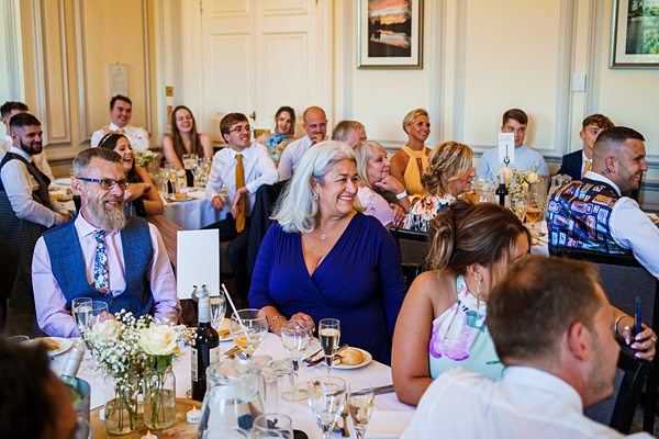 Joyful wedding reception guests dining.