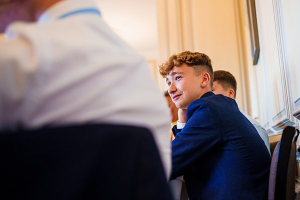 Young person smiling in a blue suit at event.