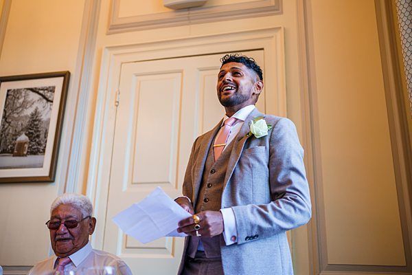 Groom giving speech at wedding reception.