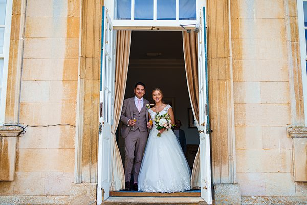 Bride and groom exiting building post-wedding ceremony.