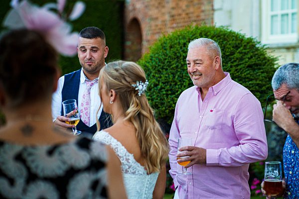 Guests socialising at outdoor wedding reception.