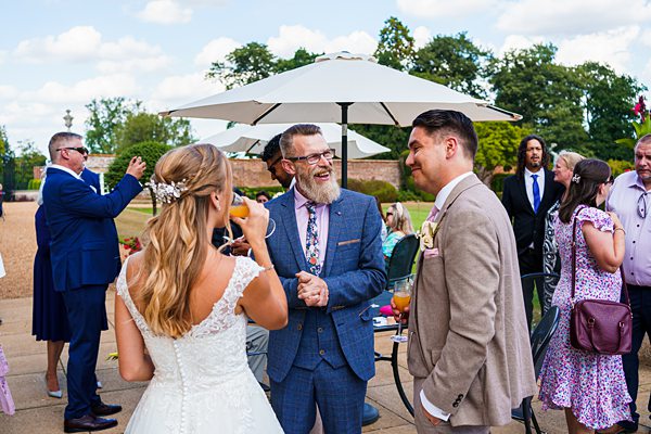 Outdoor wedding celebration with laughing guests.