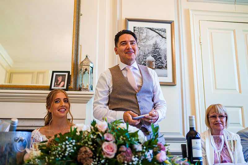 Man giving speech at wedding reception.