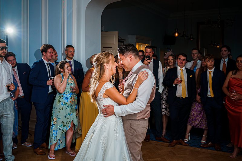 Bride and groom sharing first dance at wedding reception.