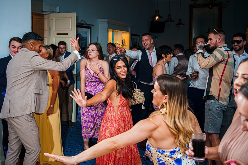 Joyful wedding reception dance floor with guests.