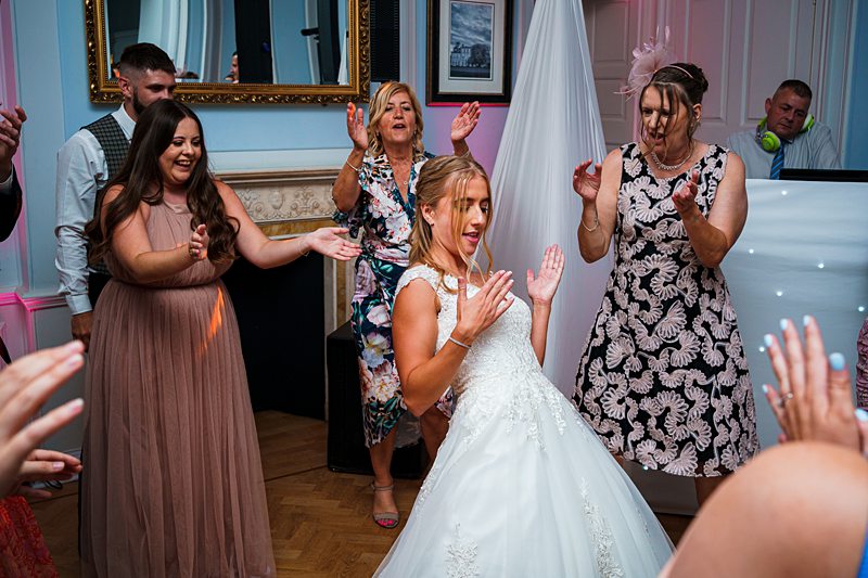 Bride and guests dancing at wedding reception.